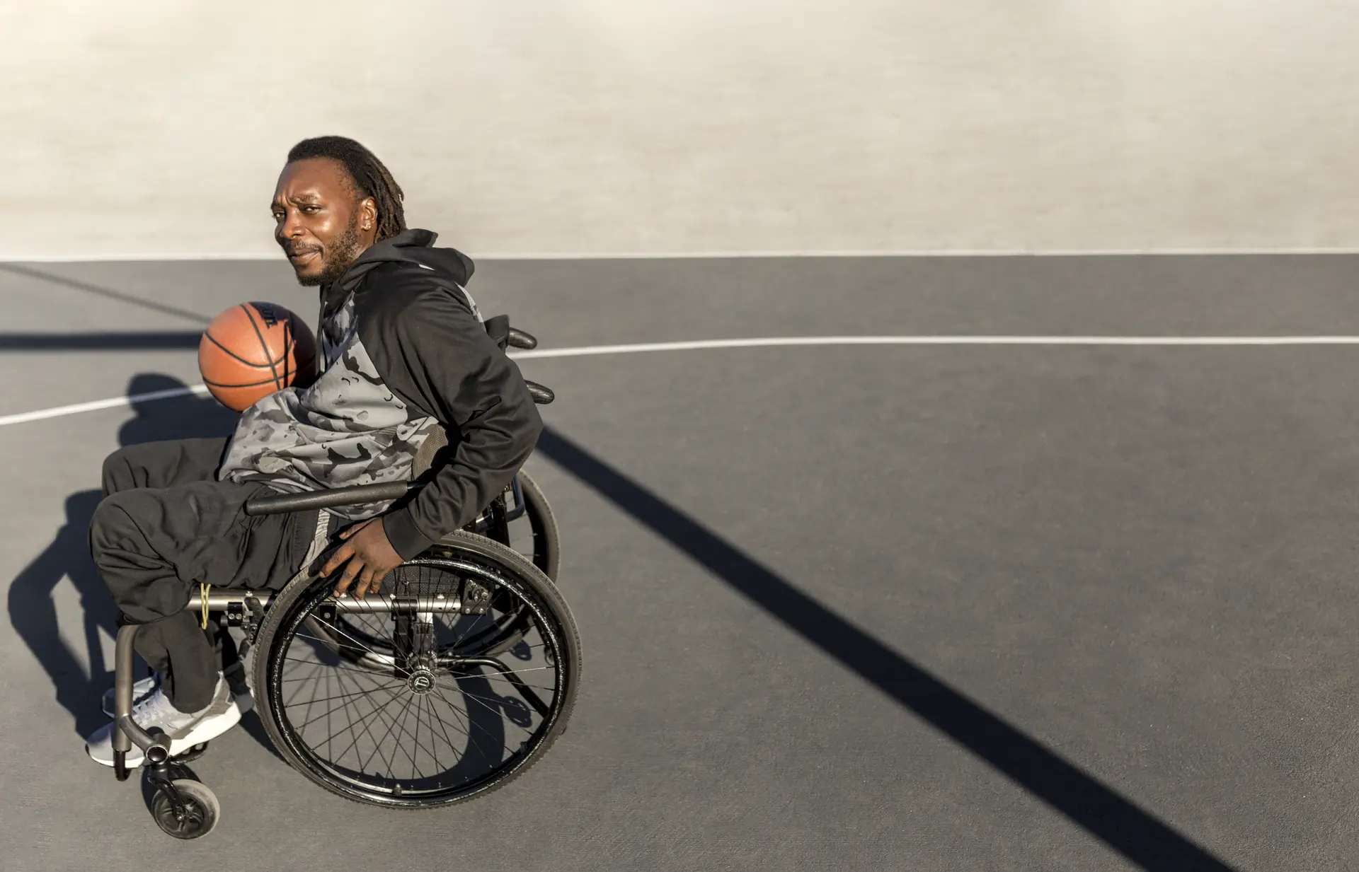 Man in wheelchair playing basketball - community engagement
